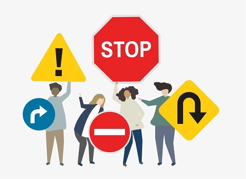 people holding traffic signs: stop, do not enter, turn, caustion

